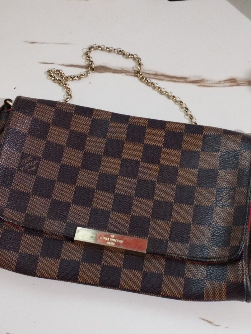 Louis Vuitton Damier Ebene Canvas Shoulder Bag (Category: Luxury Bags & Wallets) located in Quezon City. Submitted by hesperiana (Listing ID 1456315997, Image 3). Description: UKAY (not sure if legit or not) - Classic Louis Vuitton shoulder bag in Damier Ebene canvas. - Iconic checkered pattern. - Elegant gold chain strap. - Secure metal clasp closure with Louis Vuitton Paris engraving. - Luxurious red interior lining. - Versatile for everyday us