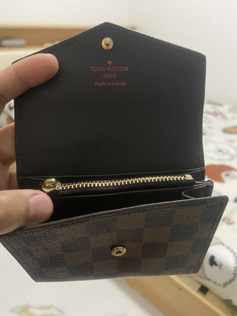Louis Vuitton Damier Ebene Small Wallet (Category: Luxury Bags & Wallets) located in Quezon City. Submitted by emjen (Listing ID 1456394500, Image 2). Description: - Louis Vuitton wallet in Damier Ebene canvas - Secure snap button closure - Convenient zip coin pocket - Interior 'Made in France' stamp and date code visible - Comes with dust bag - Ideal for everyday essentials Issue: missing zipper puller.