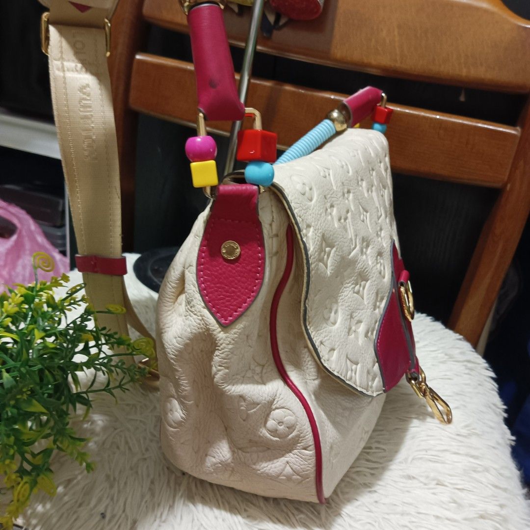 Louis Vuitton Monogram Empreinte Shoulder Bag (Category: Luxury Bags & Wallets) located in Digos. Submitted by chihanu (Listing ID 1456401491, Image 3). Description: - Cream Louis Vuitton bag with pink accents - Made from luxurious Monogram Empreinte leather - Detachable strap adorned with colorful beads - Elegant gold hardware - Chic and unique design - Versatile for both day and night use.