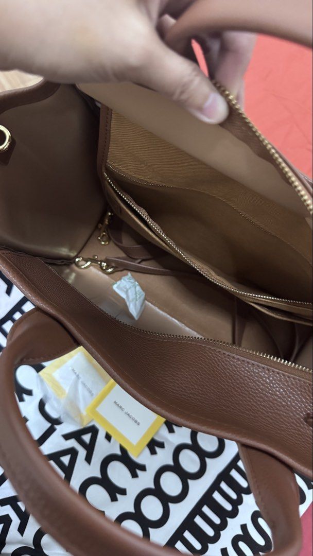 Marc Jacobs The Tote Bag (Category: Luxury Bags & Wallets) located in Batangas. Submitted by kringkring. (Listing ID 1456249359, Image 2). Description: - Authentic Marc Jacobs The Tote Bag - Color: Deep Brown - Material: Genuine Leather - Closure: Zip main compartment - Interior: Slip pockets and a zip pocket - Condition: Brand new with original tags - Ideal for: Everyday use.