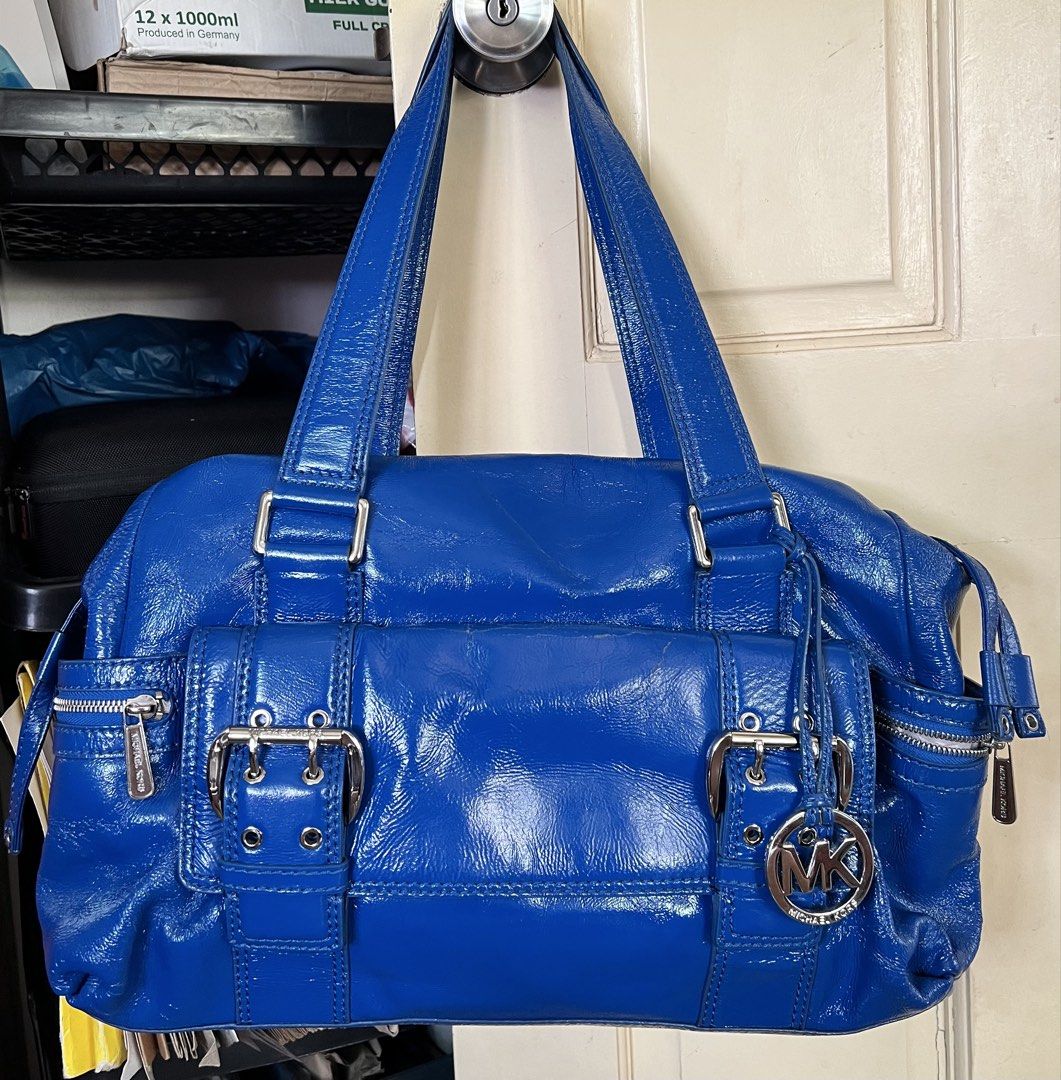 Michael Kors Blue Patent Leather Shoulder Bag (Category: Luxury Bags & Wallets) located in San Juan, Ilocos Sur. Submitted by mklover10 (Listing ID 1456374929, Image 1). Description: - Stunning bright blue Michael Kors shoulder bag - Luxurious patent leather finish - Chic silver hardware details (buckles & zippers) - Iconic MK logo charm included - Ample storage with multiple interior and exterior pockets - Ideal for stylish everyday wear.