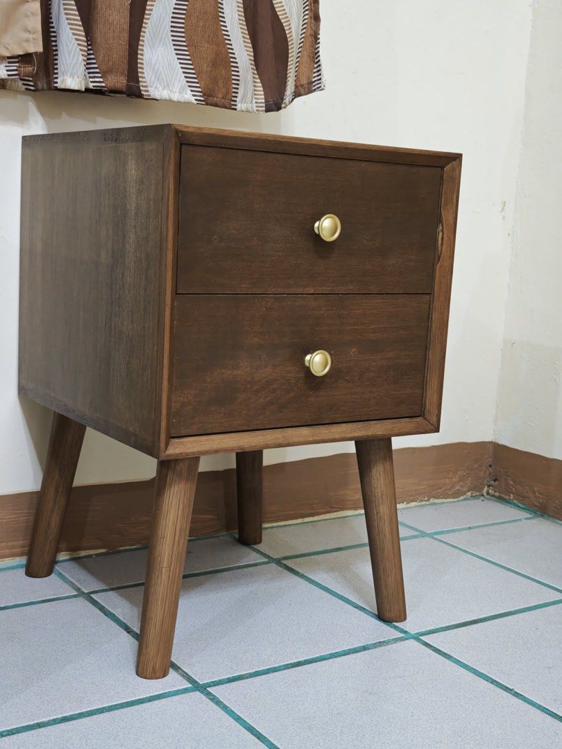 Mid-Century Modern Walnut Nightstand / Bedside Table (2-Drawers) (Category: Tables & Sets) located in Paranaque City. Submitted by FLess.ph (Listing ID 1456333605, Image 3). Description: Made to order beautiful Mid-Century Modern style nightstand / bedside table in a rich walnut finish. Features a clean geometric frame, iconic tapered legs, and two spacious drawers adorned with elegant circular gold/brass pulls. Perfect as a bedroom nightstand, l