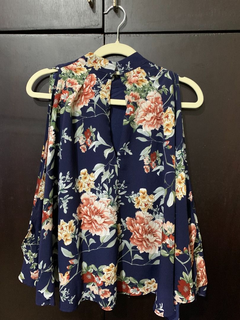 Navy Blue Floral Mock Neck Cold Shoulder Top (Category: Blouses) located in Binan City. Submitted by lviray (Listing ID 1456260261, Image 2). Description: - Navy blue top with a charming floral print. - Features a stylish mock neck and trendy cold shoulder design. - Flowy hemline creates a flattering silhouette. - Perfect for dressing up or down, easily pairs with jeans or skirts..