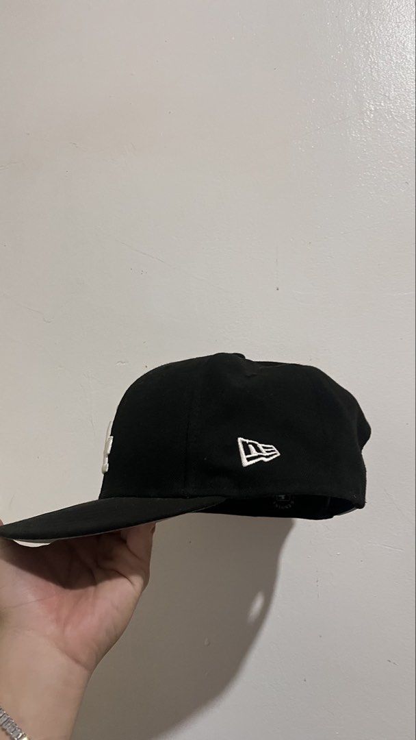 New Era 9Fifty Los Angeles Dodgers Snapback Cap (Category: Caps & Hats) located in Dinalupihan. Submitted by banditvaultco (Listing ID 1456285495, Image 3). Description: Color Scheme: Deep matte black crown, visor, and top button. Front Detail: High-density, raised 3D embroidery of the iconic interlocking white “LA” logo. Left Side: The signature white embroidered New Era flag. Right Side: A special circular monochrome patch for the “Los Angeles 