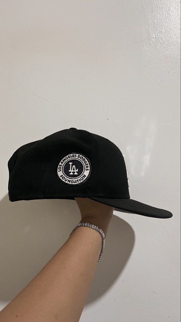 New Era 9Fifty Los Angeles Dodgers Snapback Cap (Category: Caps & Hats) located in Dinalupihan. Submitted by banditvaultco (Listing ID 1456285495, Image 2). Description: Color Scheme: Deep matte black crown, visor, and top button. Front Detail: High-density, raised 3D embroidery of the iconic interlocking white “LA” logo. Left Side: The signature white embroidered New Era flag. Right Side: A special circular monochrome patch for the “Los Angeles 