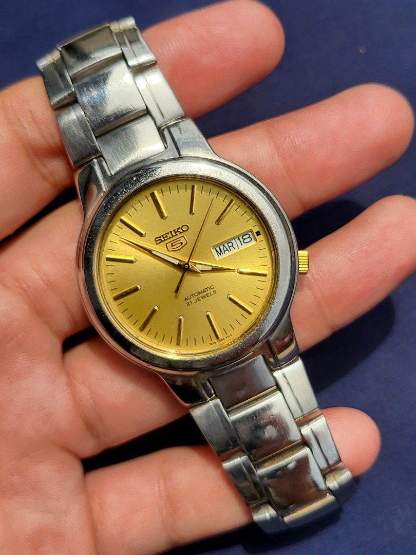 Seiko 5 Automatic "Sunburst Gold" (Category: Luxury Watches) located in Caloocan City. Submitted by oddstar_db4479 (Listing ID 1456351289, Image 1). Description: ✨ Seiko 5 Automatic "Sunburst Gold" An elegant dress watch featuring a radiant gold-tone sunburst dial, applied gold hour markers, and a sleek two-tone finish with a gold crown at 4 o'clock. The clear exhibition back gives a nice view of the reliable 21-jewel automatic movement. Lightwei