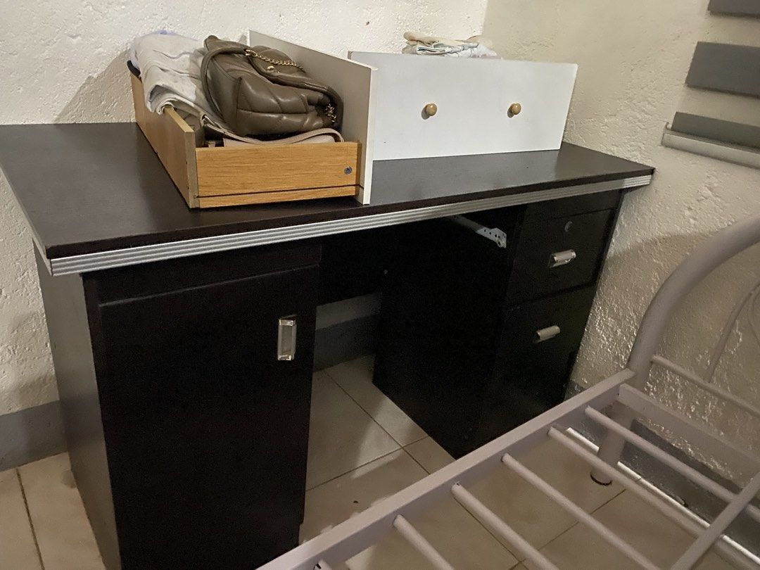 Study Table with Drawers and Cabinet (Category: Tables & Sets) located in Manila. Submitted by denisegol91095 (Listing ID 1456283004, Image 2). Description: - Dark brown desk - 3 drawers on the right side - One large cabinet on the left side - Small shelf on top (need repair) - Plenty of storage space - Ideal for study or work - Shows minor wear and tear 📌 For heavy duty.