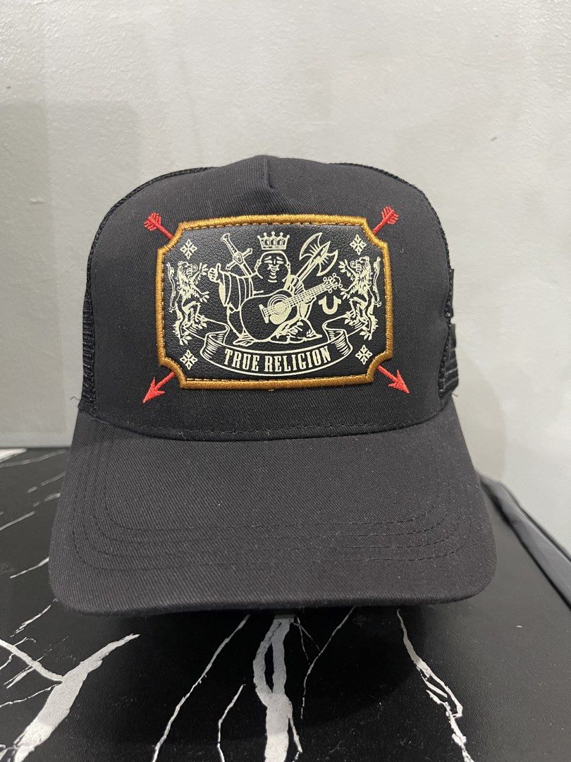 True Religion 100% Authentic Buddha Crest Mesh Trucker Cap (BELOW SRP) | The Cap Source (Category: Caps & Hats) located in Valenzuela. Submitted by oseancollective (Listing ID 1456383987, Image 1). Description: Upgrade your streetwear collection with this classic True Religion Mesh Trucker Cap. Features a high-detail embroidered True Religion Buddha crest patch on the front crown, crossed red arrow details, side mesh panels with a 3D embroidered 