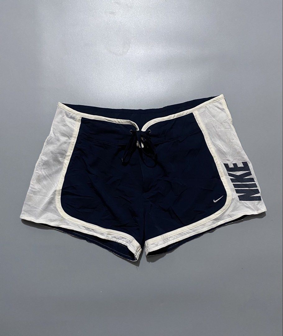 Vintage nike (Category: Shorts) located in Manila. Submitted by delunakenn94368 (Listing ID 1456234818, Image 1). Description: - Navy blue Nike running shorts - White mesh side panels with large 'NIKE' graphic - Adjustable drawstring waist - Small Nike swoosh logo on the front - Ideal for running, workouts, or casual wear.