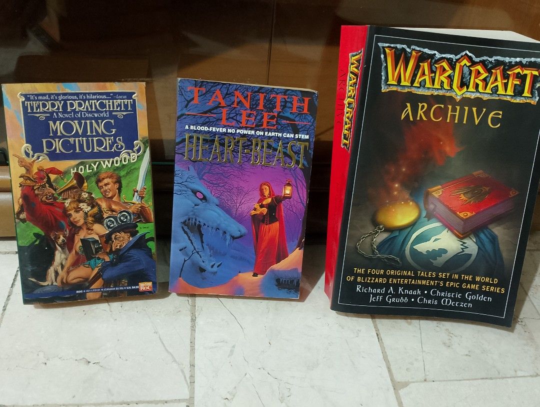 📚 FANTASY & ADVENTURE BUNDLE — 3 BOOKS! ✨ (Category: Storybooks) located in Manila. Submitted by prelovedbooks777 (Listing ID 1456569209, Image 1). Description: 1. Moving Pictures (Discworld) — Terry Pratchett’s hilarious fantasy! When the world of movies comes alive in a magical kingdom! 🎬✨ 2. Heart-Beast — A dark, enchanting tale of a woman, a mysterious beast, and an ancient blood-fever magic! 🐺🔮 3. Warcraft Archive — 4 original tales set 