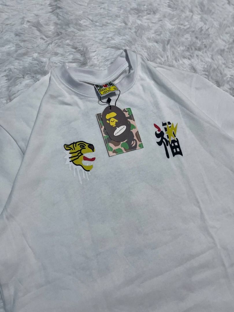 BAPE By Bathing Ape Dragon T-Shirt White (Category: Tshirts & Polo Shirts ) located in Caloocan City. Submitted by shop_tuffgoods (Listing ID 1456517307, Image 3). Description: - White BAPE T-shirt - Size: S - Features a striking dragon graphic on the back - Includes smaller graphics on the front - Comes with original tags attached - Ideal for fans of streetwear fashion - Width - 20" - Length - 28".