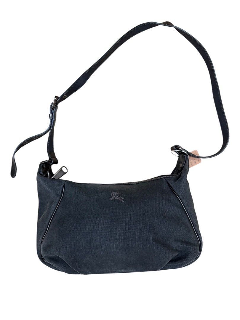 Burberry Blue Label Shoulder Bag (Category: Luxury Bags & Wallets) located in San Fernando. Submitted by northerncloset330 (Listing ID 1456552390, Image 2). Description: timeless piece from the highly collectible, Japan-exclusive diffusion line produced by Sanyo Shokai. Crafted from structurally sound, matte black canvas, the bag displays a minimalist baguette-style silhouette with subtle pleating along the base to expand its carrying capacity. T