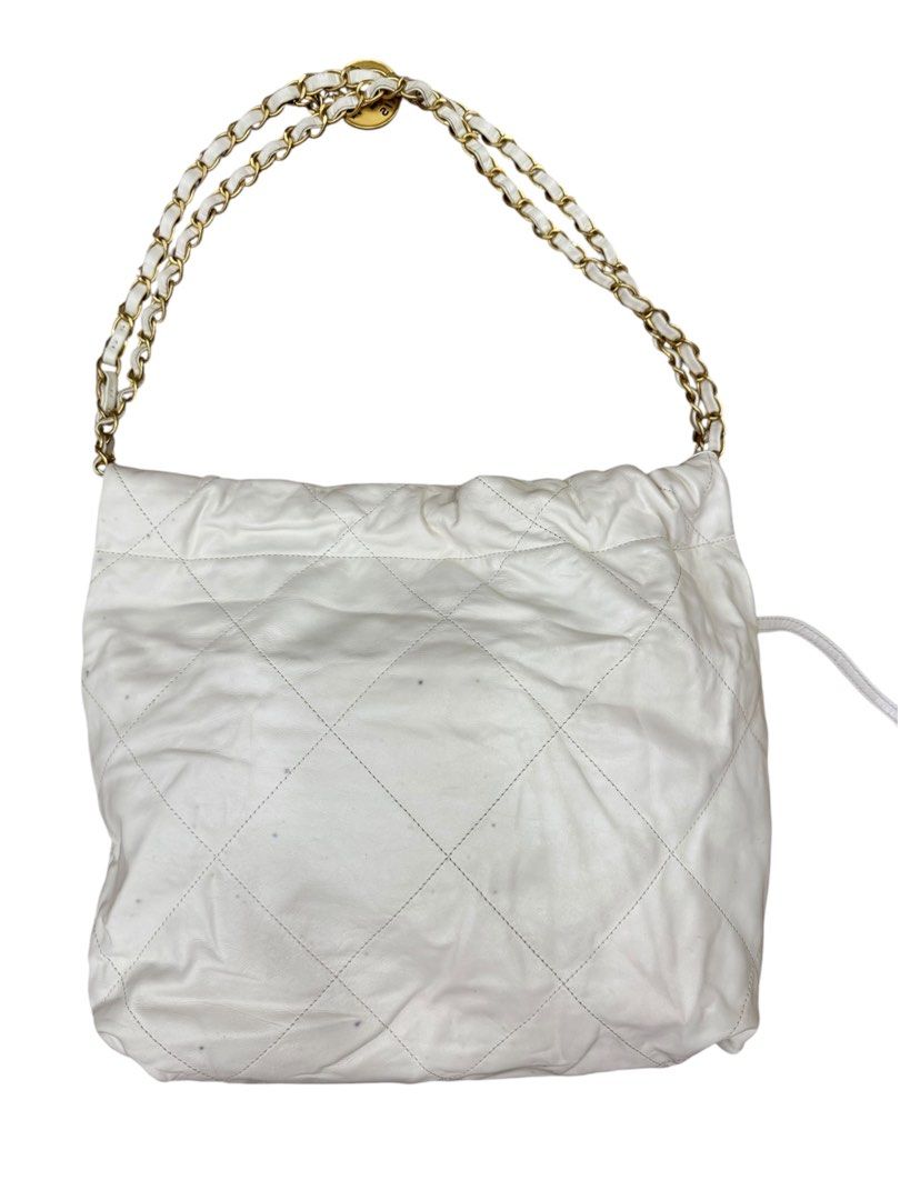 Chanel 22 (Category: Luxury Bags & Wallets) located in San Fernando. Submitted by northerncloset330 (Listing ID 1456549948, Image 2). Description: White Calfskin Hobo Bag Gold Hardware Condition Details: Overall Condition: Preloved. Exterior: The white leather shows visible color transfer, scuffing, and dark marks across the surface (please refer closely to the photos).Hardware: Gold-tone lettering and chains remain bright with minor hairline scr