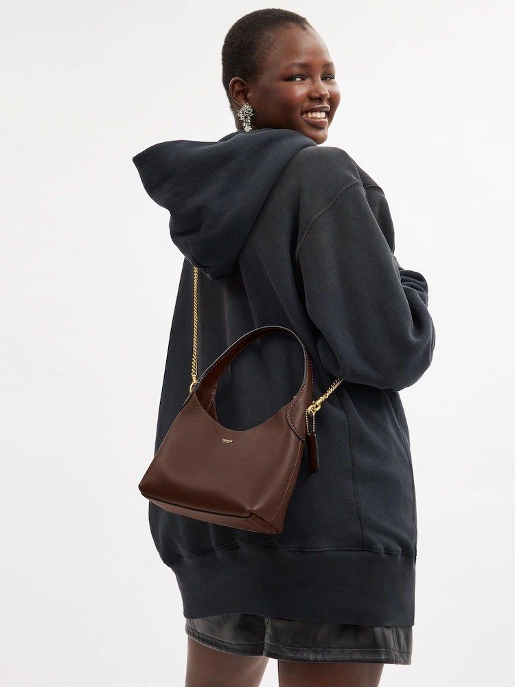 Coach Brooklyn 23 (Category: Luxury Bags & Wallets) located in Muntinlupa City. Submitted by biancaagbscloset (Listing ID 1456586539, Image 3). Description: - Chic Coach shoulder bag - Smooth brown leather - Sleek, curved silhouette - Detachable gold chain strap for versatile styling - Subtle embossed Coach logo on front - Small leather tag detail - Ideal for everyday wear or evening outings.