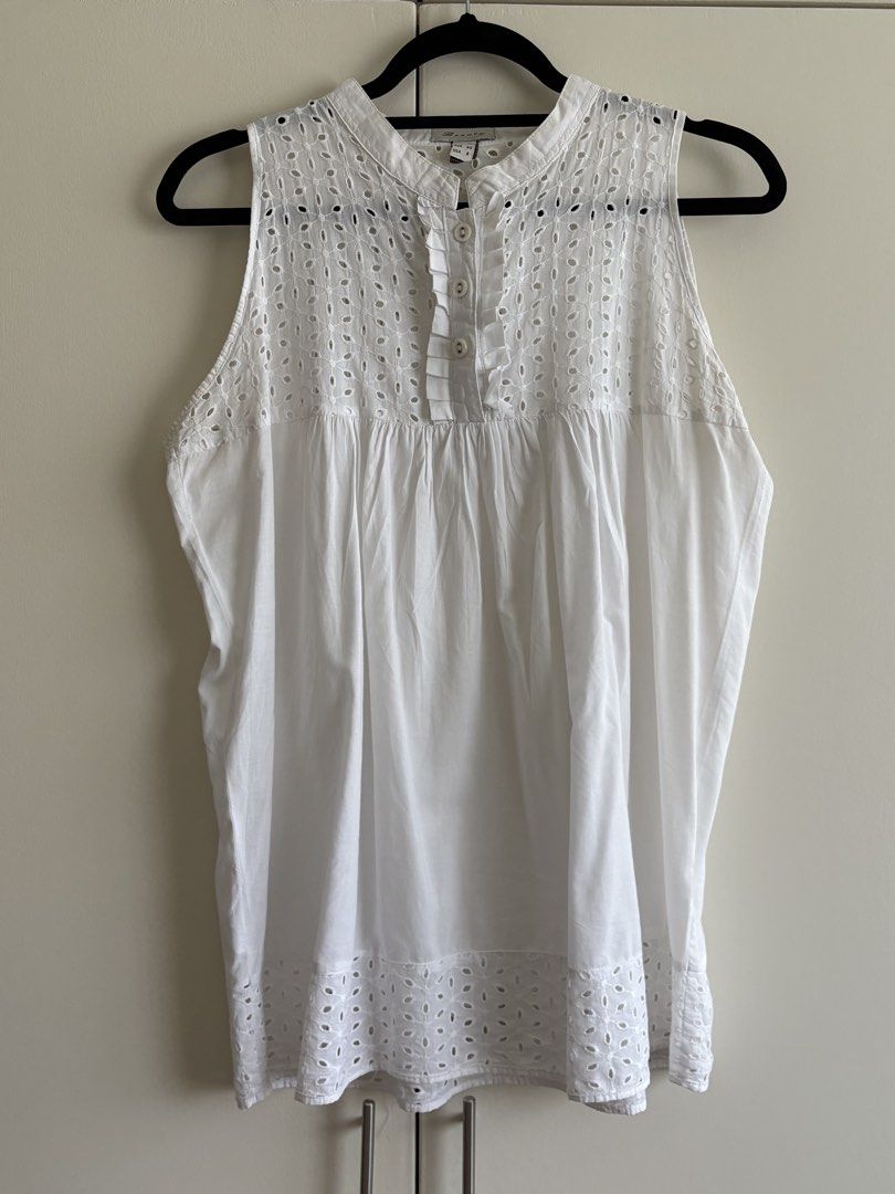 Dainty White Eyelet Sleeveless Top (Category: Sleeveless) located in Paranaque City. Submitted by macabelli (Listing ID 1456482354, Image 2). Description: - White sleeveless top - Eyelet detailing on yoke and hem - Button-up front with ruffled trim - Lightweight cotton fabric - Ideal for warm weather - Versatile styling with shorts or skirts.