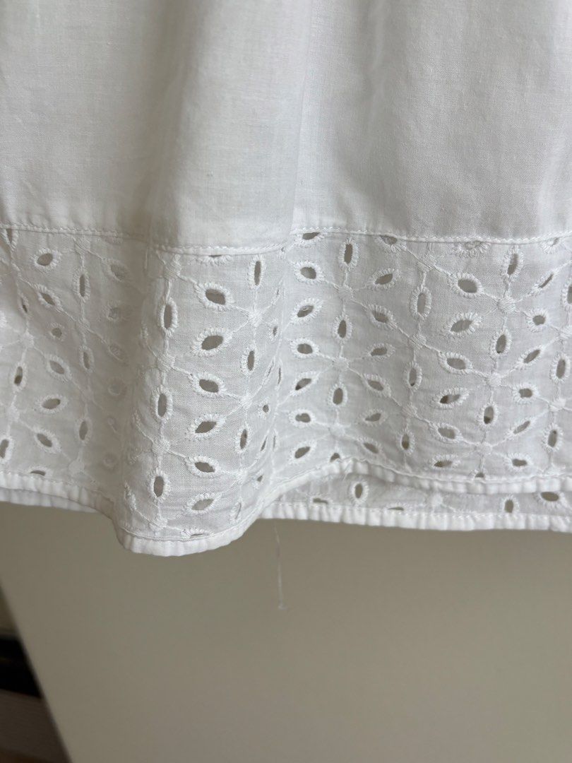 Dainty White Eyelet Sleeveless Top (Category: Sleeveless) located in Paranaque City. Submitted by macabelli (Listing ID 1456482354, Image 3). Description: - White sleeveless top - Eyelet detailing on yoke and hem - Button-up front with ruffled trim - Lightweight cotton fabric - Ideal for warm weather - Versatile styling with shorts or skirts.