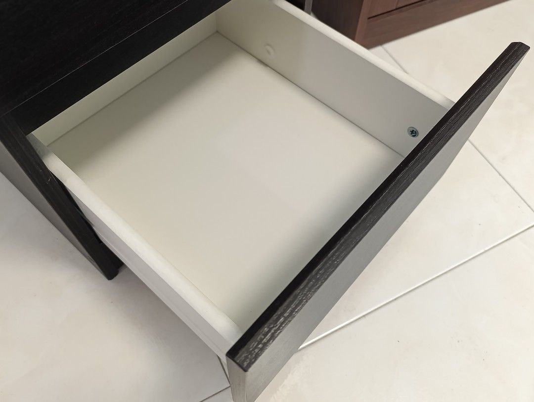 Ikea Bedside Table (Category: Tables & Sets) located in Singapore. Submitted by j2008 (Listing ID 1456449296, Image 3). Description: - Ikea Dark wood nightstand - Two smooth-sliding drawers for storage - Versatile: Ideal for bedroom or beside sofa - Compact size, fits most spaces - Easy to clean surface - Excellent condition .