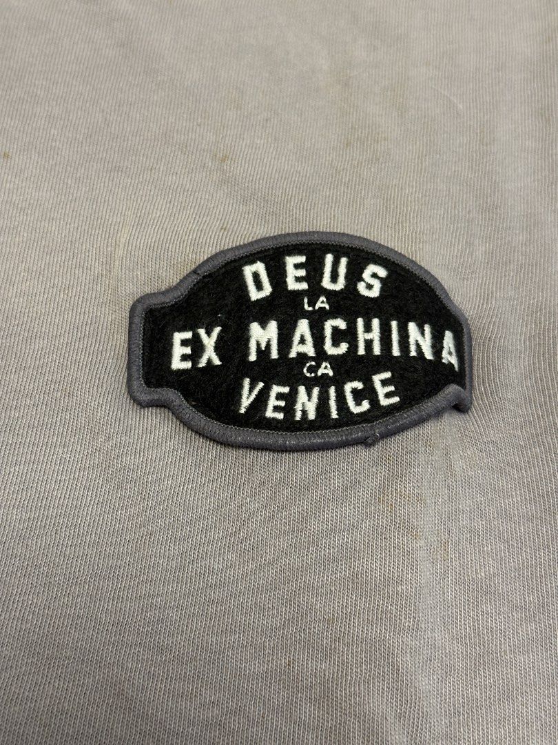 Deus Ex Machina Venice Custom Cycle Long Sleeve Tee (Category: Tshirts & Polo Shirts ) located in Quezon City. Submitted by mancave_stuff (Listing ID 1456523422, Image 3). Description: - Deus Ex Machina long sleeve t-shirt -Color: Grey - Size: Medium -W21” x L29” - Chest: 'Deus Ex Machina Venice CA' patch - Back: Large 'Deus Ex Machina Custom Cycle' graphic - Sleeve: Text graphic down the left sleeve .