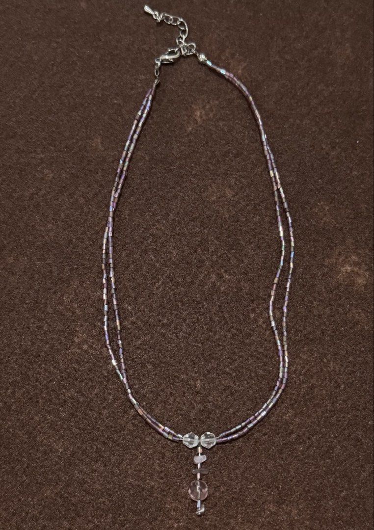 Double Strand Beaded Necklace with Crystal Pendant (Category: Necklaces) located in Quezon City. Submitted by kcapi (Listing ID 1456558531, Image 1). Description: - Double strand necklace - Made with small iridescent beads - Pendant features clear and light purple crystal-like stones - Adjustable clasp for a perfect fit - Adds a touch of sparkle to any outfit.