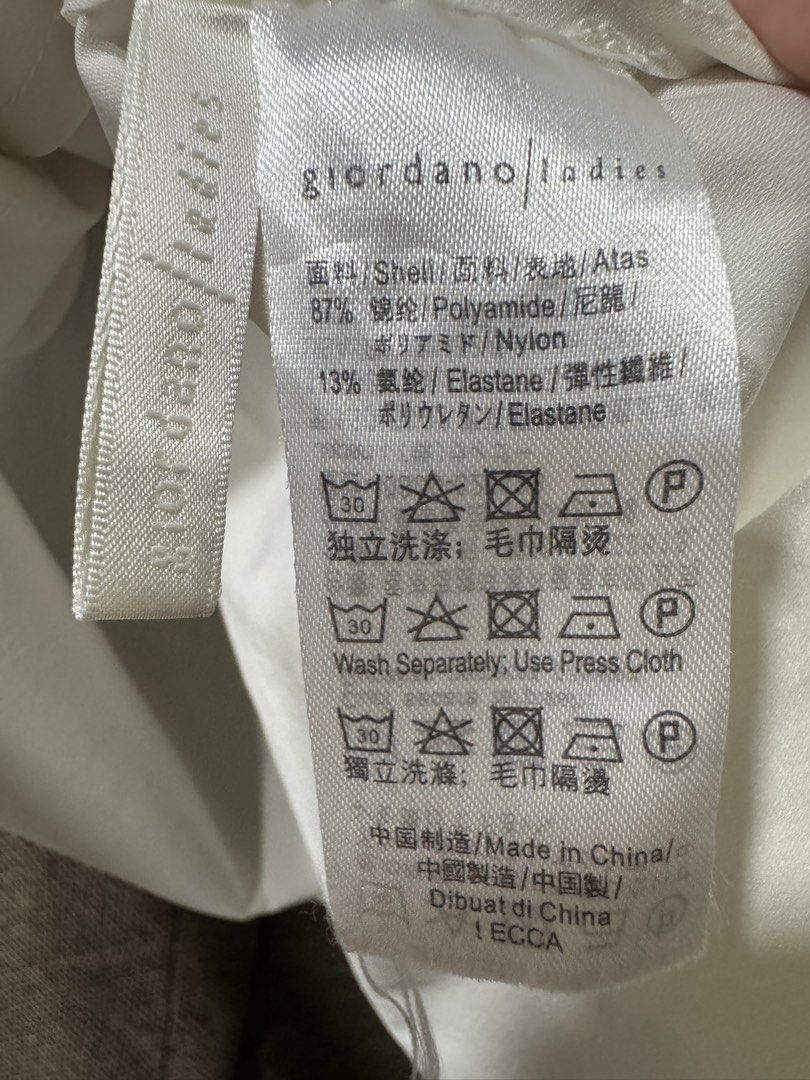 Giordano Ladies White Asymmetrical Hem Top (Category: Blouses) located in Guiguinto. Submitted by thehiddenwardrobe (Listing ID 1456571896, Image 3). Description: - Giordano Ladies white top - Short sleeves - Asymmetrical hemline - Material: Polyamide and elastane blend - Chest measurement: Approximately 22 inches - Condition: Small faint stain on the back (refer to last photo) - Perfect for casual wear.