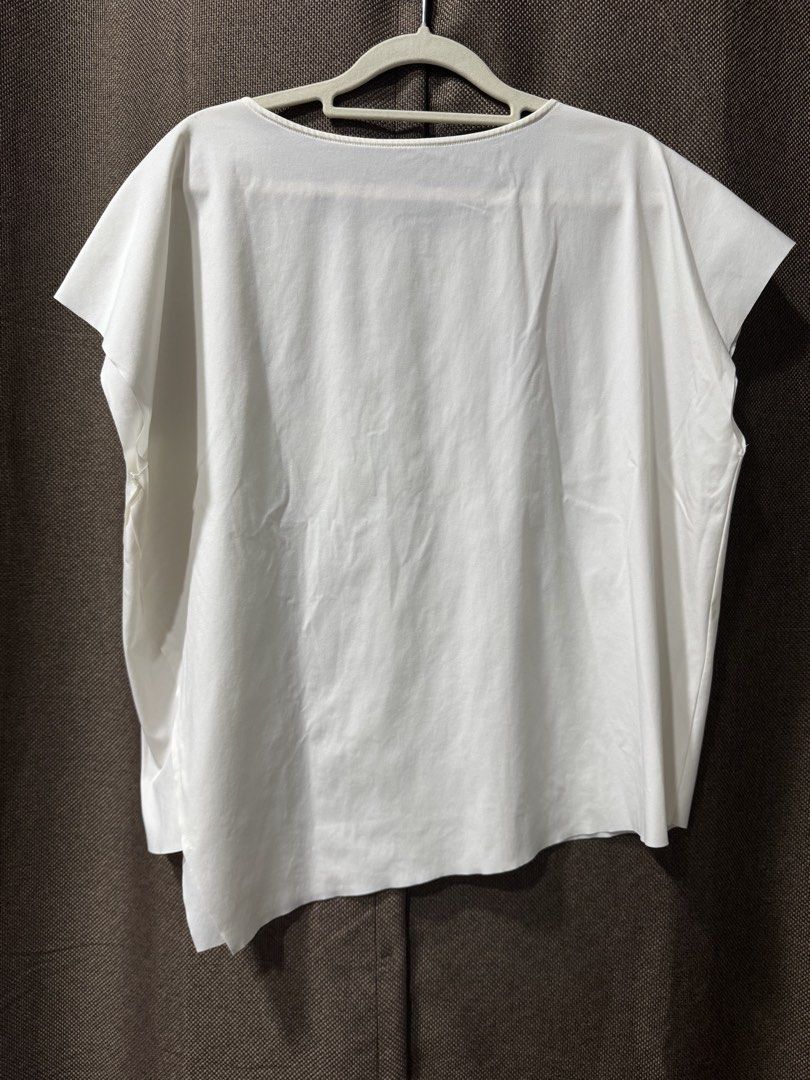 Giordano Ladies White Asymmetrical Hem Top (Category: Blouses) located in Guiguinto. Submitted by thehiddenwardrobe (Listing ID 1456571896, Image 2). Description: - Giordano Ladies white top - Short sleeves - Asymmetrical hemline - Material: Polyamide and elastane blend - Chest measurement: Approximately 22 inches - Condition: Small faint stain on the back (refer to last photo) - Perfect for casual wear.