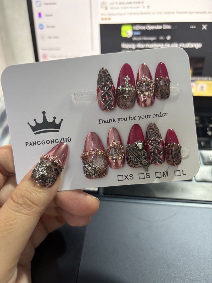 Hand Made Press-On Nails Medium (Category: Hands & Nails) located in Mexico. Submitted by 3everything (Listing ID 1456483875, Image 1). Description: - Custom press-on nail set - Features leopard print, metallic pink, and rhinestone designs - Adorned with charms like crosses and stars - Perfect for a bold, statement look.