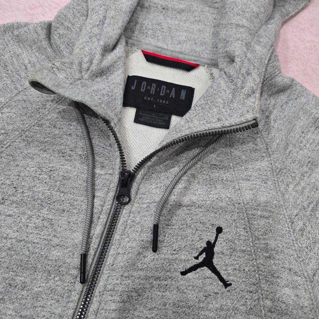 Jordan Grey Zip-Up Hoodie Size L (Category: Coats, Jackets and Outerwear) located in Abucay. Submitted by pickd.pn (Listing ID 1456496143, Image 1). Description: - Grey Jordan zip-up hoodie - Thick cotton - Very Good Condition. Need wash lang - Large on tag.