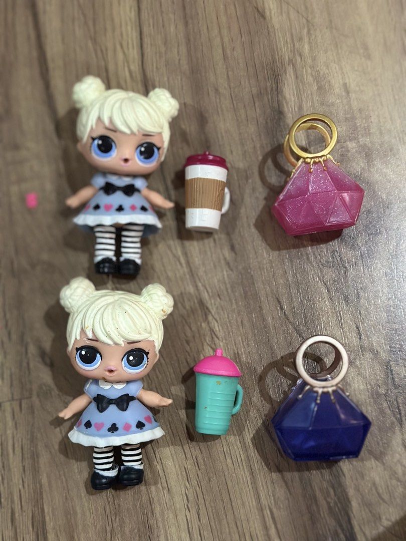 LOL Surprise Dolls with Accessories (Category: Kids Toys) located in Baguio. Submitted by cherylcaps95 (Listing ID 1456484453, Image 1). Description: - Two LOL Surprise dolls included. - Dolls have blonde hair styled in buns. - Each doll wears a blue dress with card suit patterns. - Features black and white striped socks. - Accessories include two drink bottles and two gem-shaped purses. - Ideal for LOL Surprise collectors and playtime fun..
