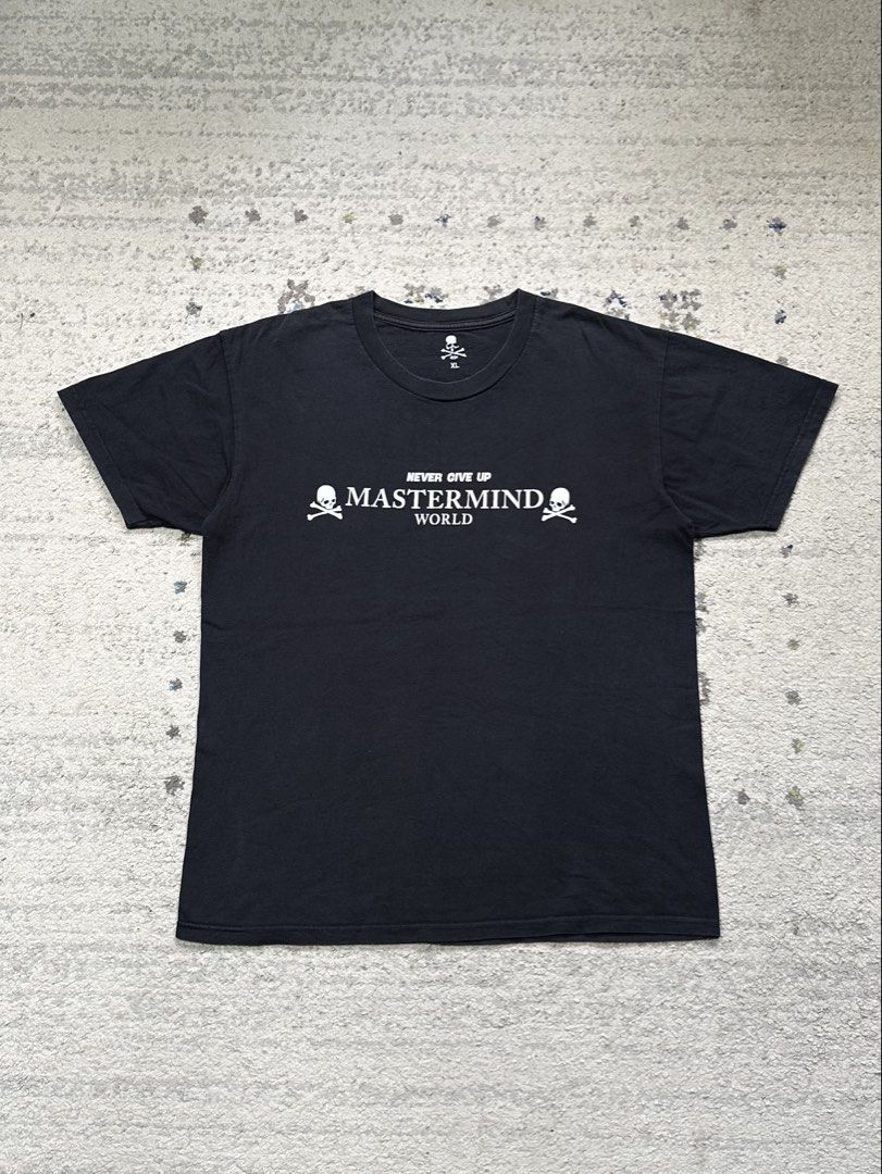 Mastermind World T-Shirt Skull Crossbones Logo Black (Category: Tshirts & Polo Shirts ) located in Daet. Submitted by thrifthings2018 (Listing ID 1456482295, Image 2). Description: - Authentic Mastermind World t-shirt - Features the iconic 'Never Give Up' slogan on the front - Includes skull and crossbones graphics - 'Lazy Boy' text and large skull graphic on the back - Measurements: 21.5 inches width, 28 inches length - Price: P450.