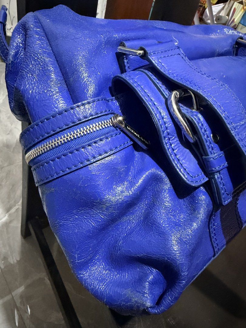 Michael Kors Blue Patent Leather Shoulder Bag (Category: Luxury Bags & Wallets) located in San Juan, Ilocos Sur. Submitted by mklover10 (Listing ID 1456374929, Image 2). Description: - Stunning bright blue Michael Kors shoulder bag - Luxurious patent leather finish - Chic silver hardware details (buckles & zippers) - Iconic MK logo charm included - Ample storage with multiple interior and exterior pockets - Ideal for stylish everyday wear.