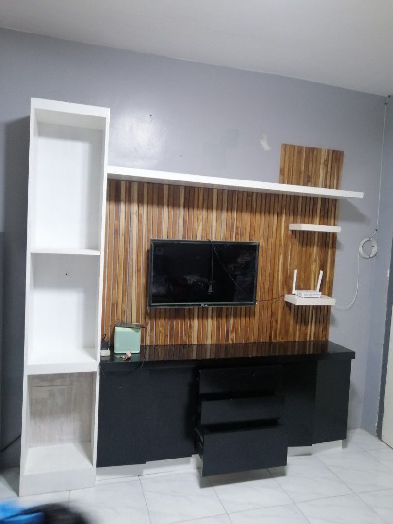 Modern TV Console with Wall Shelving Unit (Category: TV Consoles) located in Rizal. Submitted by rome_25 (Listing ID 1456551937, Image 2). Description: - Sleek TV console with a stylish wooden accent wall panel. - Includes a tall white shelving unit for additional display or storage. - Plenty of storage space with convenient drawers and open shelves. - Perfect for organizing and decluttering your entertainment area. - Dimensions: [insert dimensio