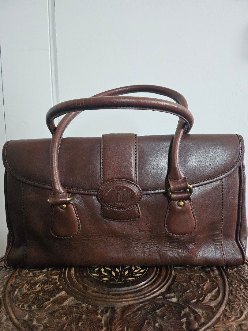 Nicole St Gilles Brown Leather Handbag (Category: Luxury Bags & Wallets) located in Mandaue City. Submitted by ecanusph (Listing ID 1456496557, Image 1). Description: - Classic brown genuine leather handbag - Main compartment with zip closureon smaller compartment - Multiple interior pockets for organization - Sturdy material - 14 x 4 x 9 inches - Some wear on bottom corners - Great everyday bag .
