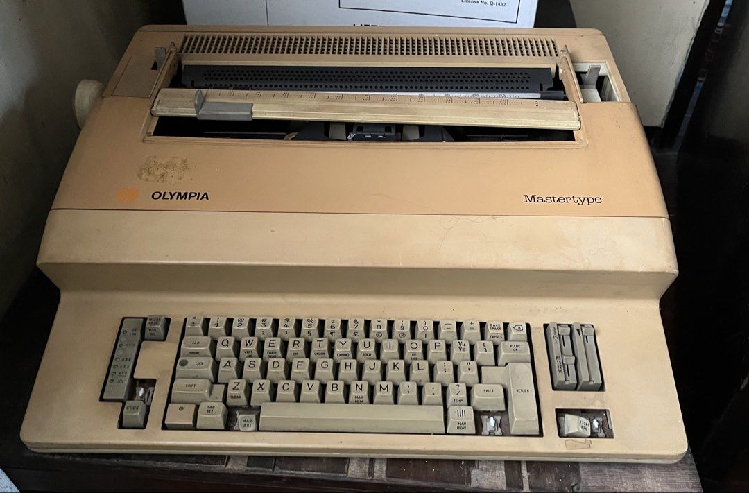 Olympia Mastertype Electric Typewriter for Restoration / Parts (Category: Office & Business Technology) located in Manila. Submitted by laurenstaste (Listing ID 1456595044, Image 1). Description: - Vintage Olympia Mastertype electric typewriter - Classic QWERTY keyboard layout - Light beige casing - Minor scuffs and marks on casing - Ideal for collectors or retro aesthetic enthusiasts.