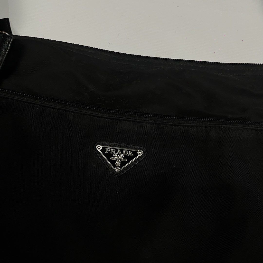 Prada Nylon Crossbody Bag Black (Category: Luxury Bags & Wallets) located in Lucena. Submitted by nifty_finds (Listing ID 1456601900, Image 2). Description: - Classic black Prada nylon crossbody bag - Features iconic Prada triangle logo on the front - Adjustable strap for comfortable wear - Interior zip pocket and main compartment - Perfect for everyday use - Shows minimal signs of wear -Complete Tags .