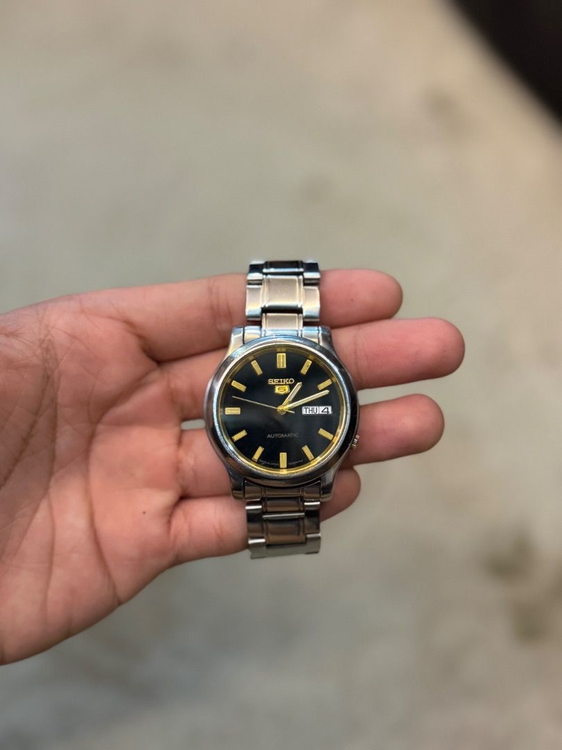 SEIKO 5 "BLACK GOLD" (Category: Luxury Watches) located in Andop. Submitted by john_karl23 (Listing ID 1456427385, Image 2). Description: Seiko 5 Vintage Automatic Watch Seiko 5 Vintage Automatic Ref. 7S26-02J0 A dependable Japanese watch with a 37 mm stainless steel case, black dial touched with gold, and a handy day-date display. Powered by Seiko’s trusted 7S26 automatic movement, it’s built for everyday wear with timeless style. 📌Newly Servic