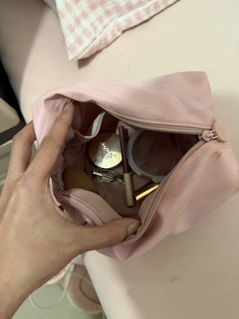 Sunnies Pink Cosmetic Bag (Category: Makeup) located in Davao. Submitted by fabdeclutter (Listing ID 1456599044, Image 2). Description: - Pink makeup pouch - Exterior stains visible in photos - Interior includes: makeup sponge, eyelash curler, eyeliner pencil, compact powder - Zipper in good working condition - Ideal for travel or everyday use.