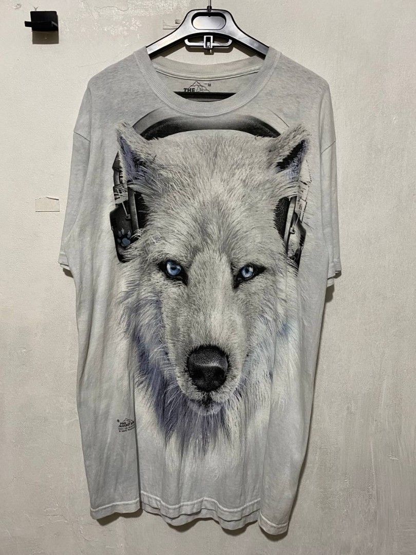 The Mountain White Wolf T-Shirt Size M (Category: Tshirts & Polo Shirts ) located in Caloocan City. Submitted by brandon.regalado2 (Listing ID 1456589355, Image 1). Description: 20 / 31 EXCELLENT NO ISSUE - Cool graphic tee from The Mountain - Features a detailed print of a white wolf wearing headphones - 100% cotton, made in Mexico - Size: Medium - Great for wolf enthusiasts and unique animal print fans.