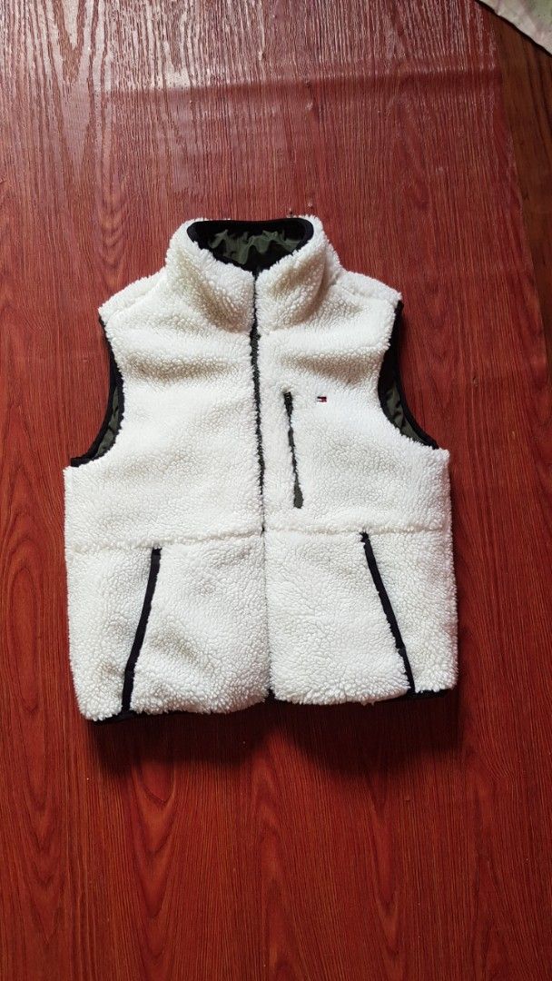 Tommy Hilfiger Reversible Puffer Vest (Category: Vests) located in Manila. Submitted by nice430 (Listing ID 1456489384, Image 1). Description: - Reversible Tommy Hilfiger vest - Side 1: Fluffy white sherpa with black trim - Side 2: Quilted olive green puffer with black trim - Zippered pockets on both sides - Ideal for layering.