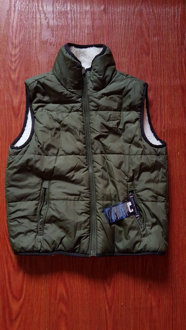 Tommy Hilfiger Reversible Puffer Vest (Category: Vests) located in Manila. Submitted by nice430 (Listing ID 1456489384, Image 2). Description: - Reversible Tommy Hilfiger vest - Side 1: Fluffy white sherpa with black trim - Side 2: Quilted olive green puffer with black trim - Zippered pockets on both sides - Ideal for layering.