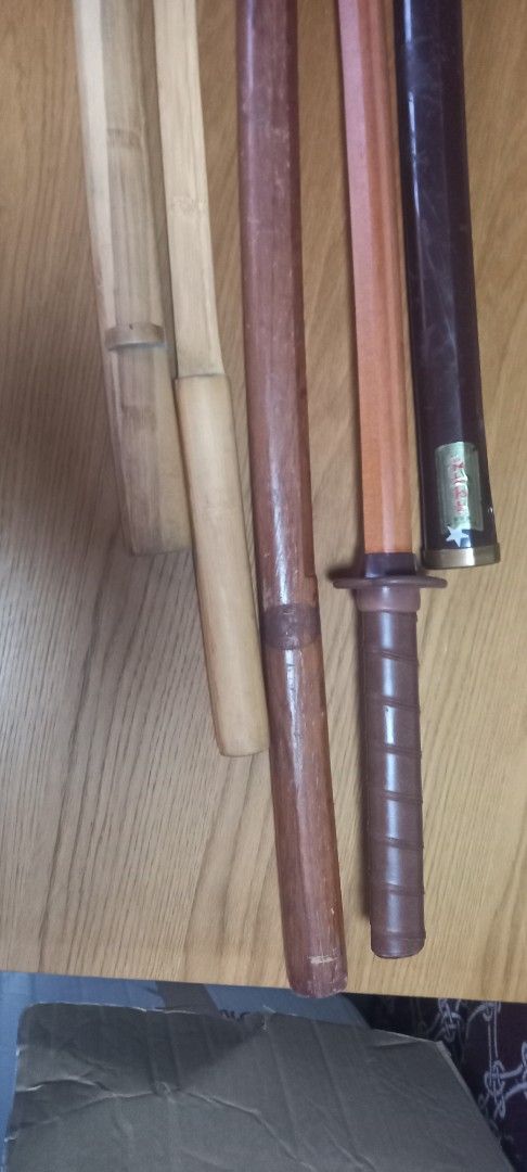 Wooden Practice Sword with Sheath (Category: Musical Instruments) located in Manila. Submitted by fmpc7878 (Listing ID 1456517857, Image 2). Description: - Wooden practice sword - Includes two saya (sheaths): one dark brown, one light wood - Tsuka (handle) wrapped in brown material - Dark brown saya features a 'MADE IN KOREA' label - Suitable for display or practice Take all Price for 500 AS IS ABUSED CONDITION WITH ITS FLAWS.