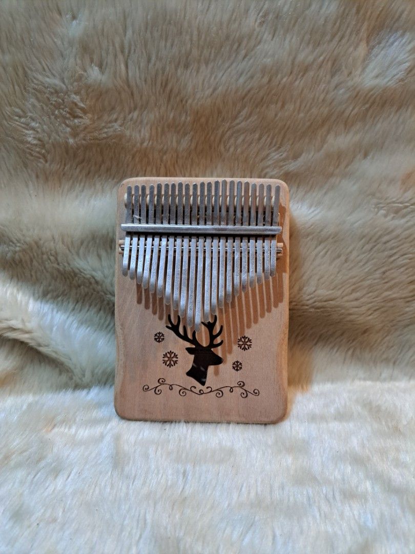 17 Key Kalimba Thumb Piano with Deer Design (Category: Musical Instruments) located in Quezon City. Submitted by sbvdmanaog (Listing ID 1453419008, Image 1). Description: - Adorable wooden 17-key kalimba with a cute deer and snowflake design. - Ideal for beginners and music enthusiasts. - Easy to play and highly portable for on-the-go melodies. - Perfect for creating relaxing and soothing music. - Features two sound holes on the back for enhanced