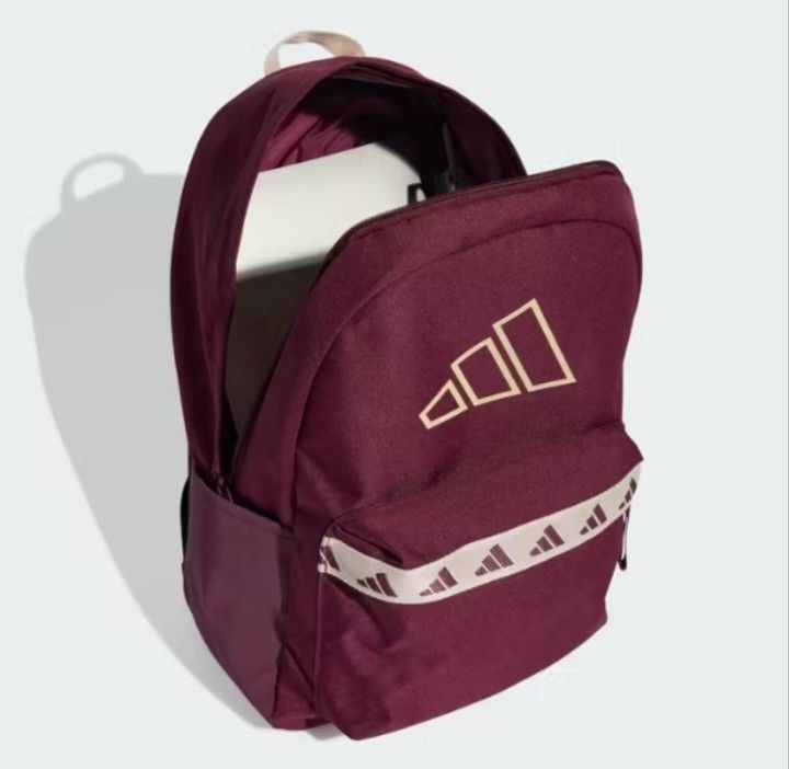 Adidas Burgundy Backpack 27.4L - 3 Bar Logo (Category: Backpacks) located in Valenzuela. Submitted by jc120505 (Listing ID 1453346793, Image 2). Description: - Stylish burgundy Adidas backpack with prominent 3 Bar Logo. - Spacious main compartment with wide opening - Features 3 Bar Logo tape across the front zip pocket. - Comfortable padded and adjustable shoulder straps. - Generous 27.4L volume. - Dimensions: 15 cm (width) x 31 cm (depth) x 44 c