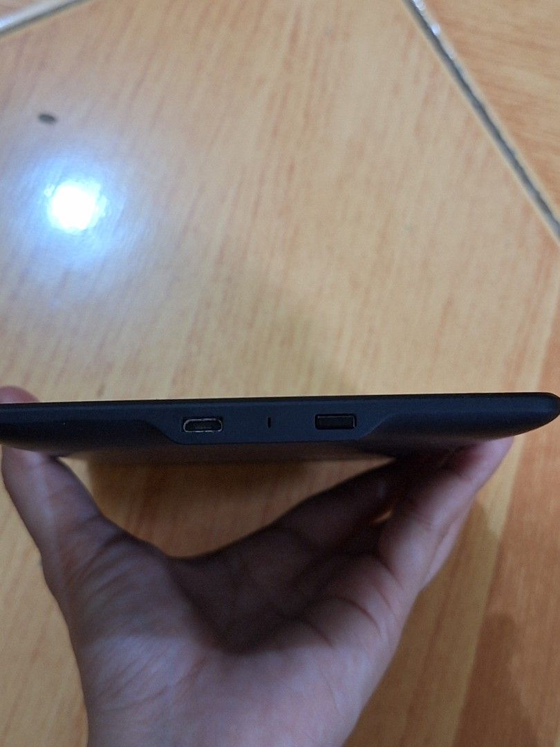 Amazon Kindle E-reader - Black (Category: E-Readers) located in Taguig. Submitted by dani1115 (Listing ID 1453247330, Image 3). Description: - Black Amazon Kindle e-reader - Shows a low battery icon on screen - Features Amazon logo on the back - Power button and charging port visible on the side - Ideal for reading books on the go RFS: Hindi nagagamit Bilhan nyo na lang charger.