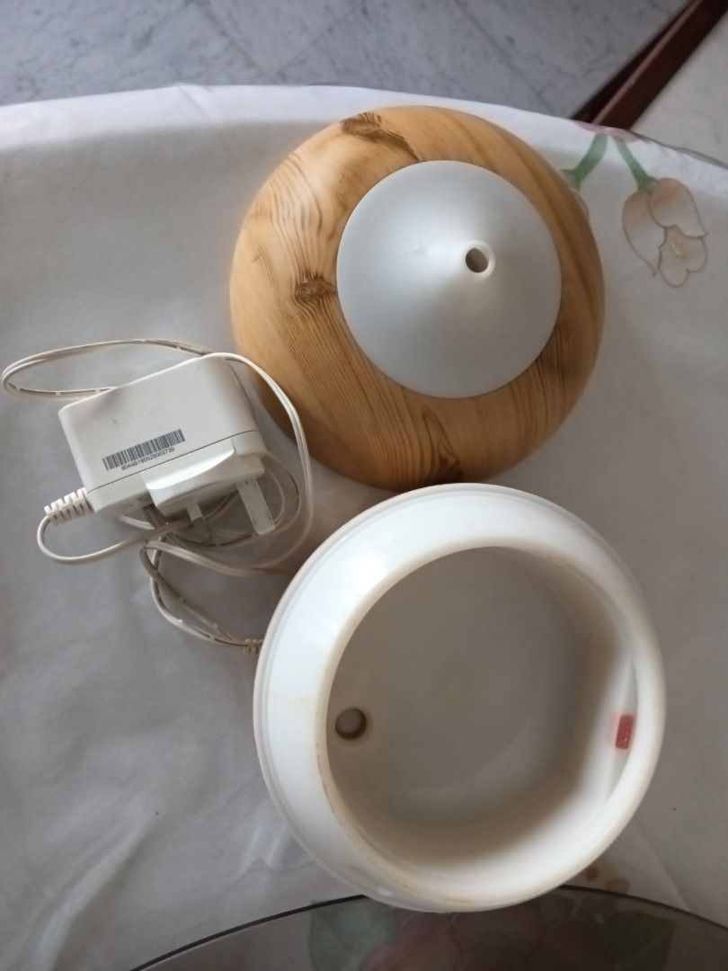 Aroma diffuser (Category: Home Fragrance) located in Singapore. Submitted by wqcrecycler (Listing ID 1453338634, Image 3). Description: - Aroma diffuser with a stylish wood-grain top and white base, - variable colourful light - Comes with the necessary power adapter. - In good working condition. - Perfect for home fragrance and creating a relaxing atmosphere. - Meetups available in Bishan..