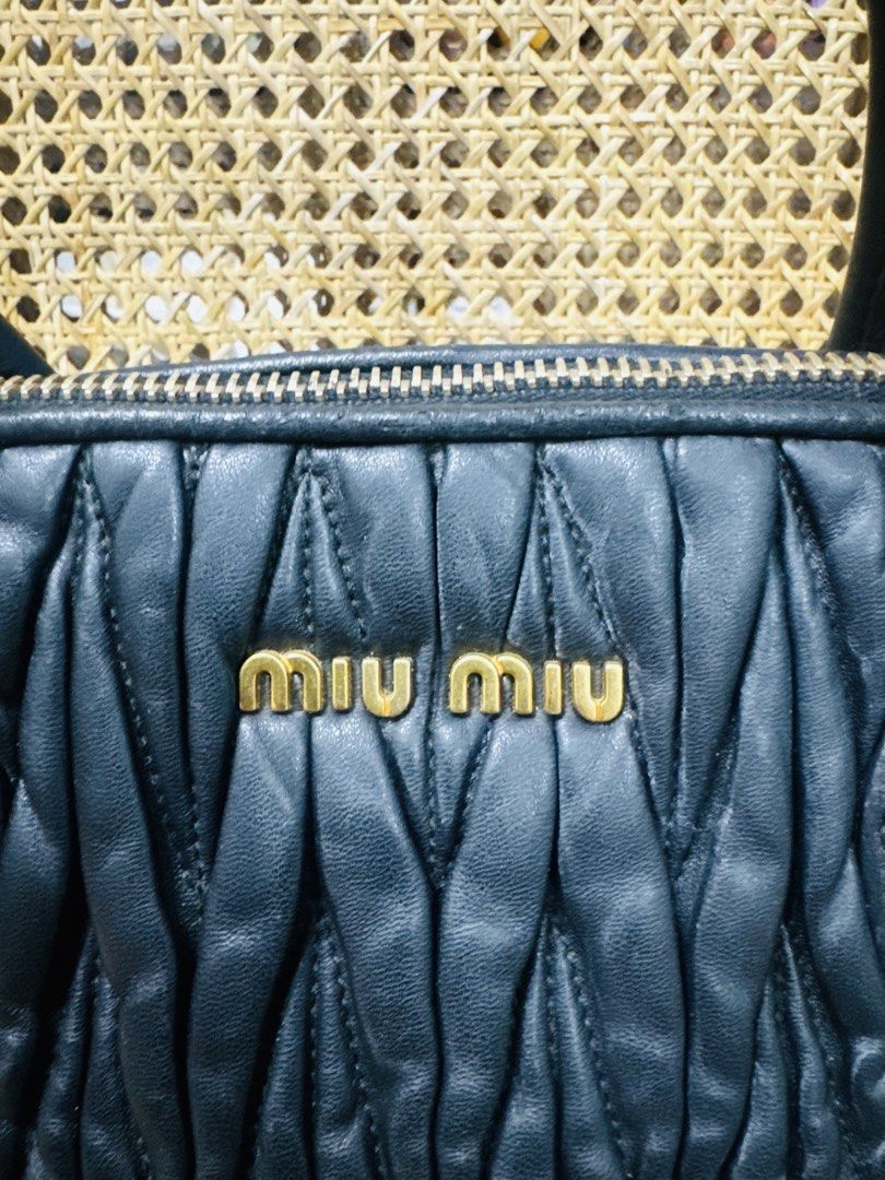 [AUTHENTIC] Miu Miu Black Matalasse Tote (Category: Luxury Bags & Wallets) located in Santa Rosa. Submitted by rjaarmblo (Listing ID 1453386921, Image 2). Description: - Elegant black leather handbag - Unique ruched texture for added style - Prominent gold zipper with a distinctive pull tab - Subtle patterned interior lining - Classic design, a versatile accessory - Zipper on the sides for expanding - Comes with strap.