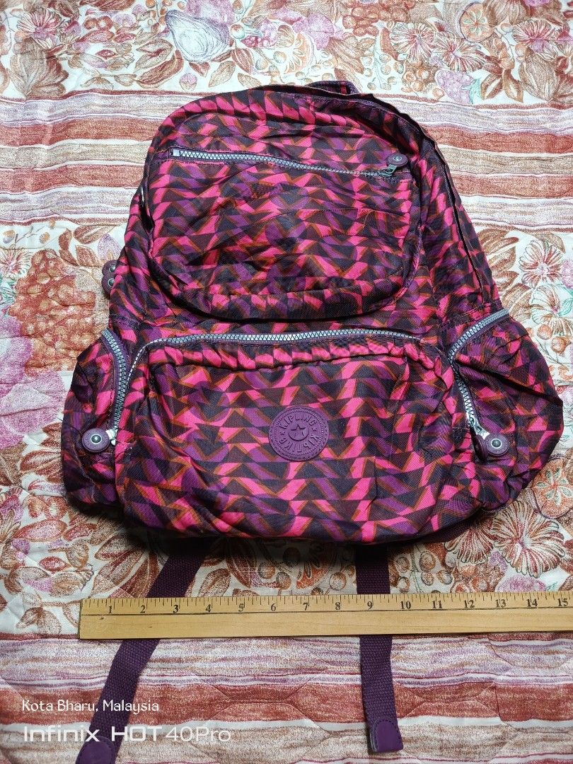 Backpack Kipling (Category: Backpacks) located in Kuala Lumpur. Submitted by grandturtle_dd5ca3 (Listing ID 1453422943, Image 1). Description: Brand: Kipling. Model: Similar to the City Pack line. Color/Pattern: Pink and Burgundy geometric pattern. Features: Features a main compartment and multiple zippered pockets.