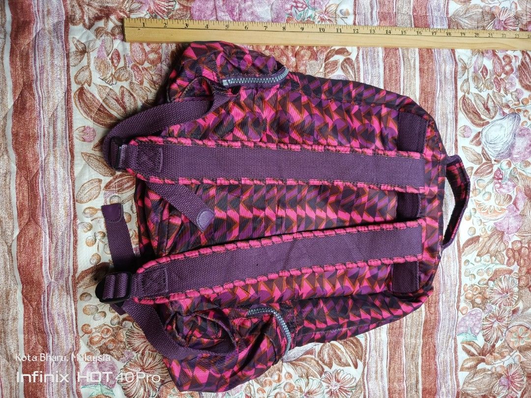 Backpack Kipling (Category: Backpacks) located in Kuala Lumpur. Submitted by grandturtle_dd5ca3 (Listing ID 1453422943, Image 2). Description: Brand: Kipling. Model: Similar to the City Pack line. Color/Pattern: Pink and Burgundy geometric pattern. Features: Features a main compartment and multiple zippered pockets.