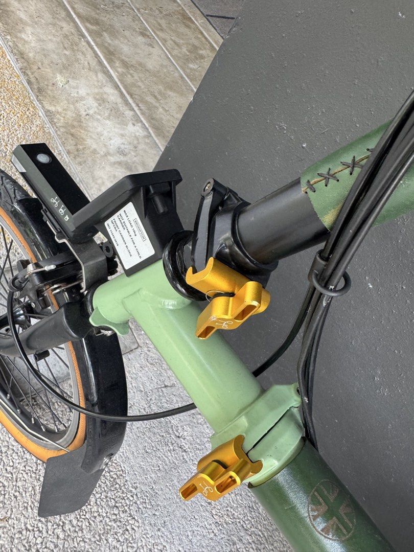 Brompton (Category: Bicycles) located in Singapore. Submitted by jungoogi60563 (Listing ID 1453372257, Image 3). Description: Brompton C Line Explore M6R, 6-speed with rear rack, two-tone green. Bought [2023], approx. Always stored indoors. Upgraded with genuine Brompton parts: • ColourLab Touchpoint Set in GOLD (Q103763): hinge clamps, levers, saddle QR, rear frame clip, tri-spoke roller wheels. RRP S$215 • Brompton 500lm front light + front car