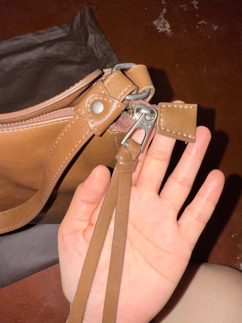 Brown Leather Shoulder Bag with Detachable Strap (Category: Shoulder Bags) located in Bulacan. Submitted by jhe_anne (Listing ID 1453242129, Image 2). Description: - Genuine brown leather shoulder bag - Main zip compartment for secure storage - Internal zip pocket for organization - Detachable shoulder strap for versatility - Beautiful natural leather sheen - Includes a protective dust bag - Ideal everyday companion.