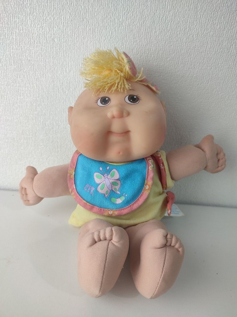 Cabbage Patch Kid Doll with Bib and Outfit (Category: Babies & Kids Fashion) located in Manila. Submitted by epicmountain-f20453 (Listing ID 1453290180, Image 1). Description: - Vintage Cabbage Patch Kid doll - Blonde hair - Cute butterfly bib - Yellow and pink outfit - Made by Original Appalachian Artworks - Great for collectors or play - A classic toy.